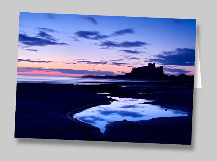 A greeting card featuring a view of Bamburgh Castle before dawn, Northumberland
